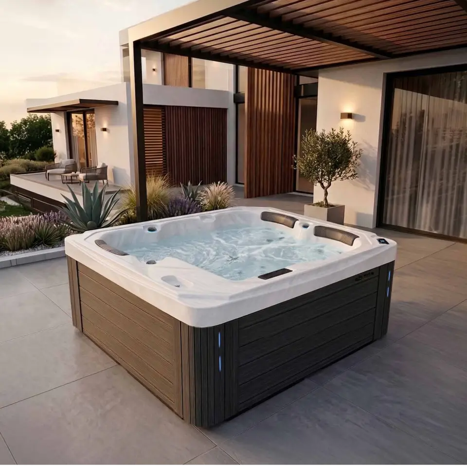 A spa with wooden style texture on the sides and white marble texture for the top and interior sits on a tiled patio of a open style residence with greenery around