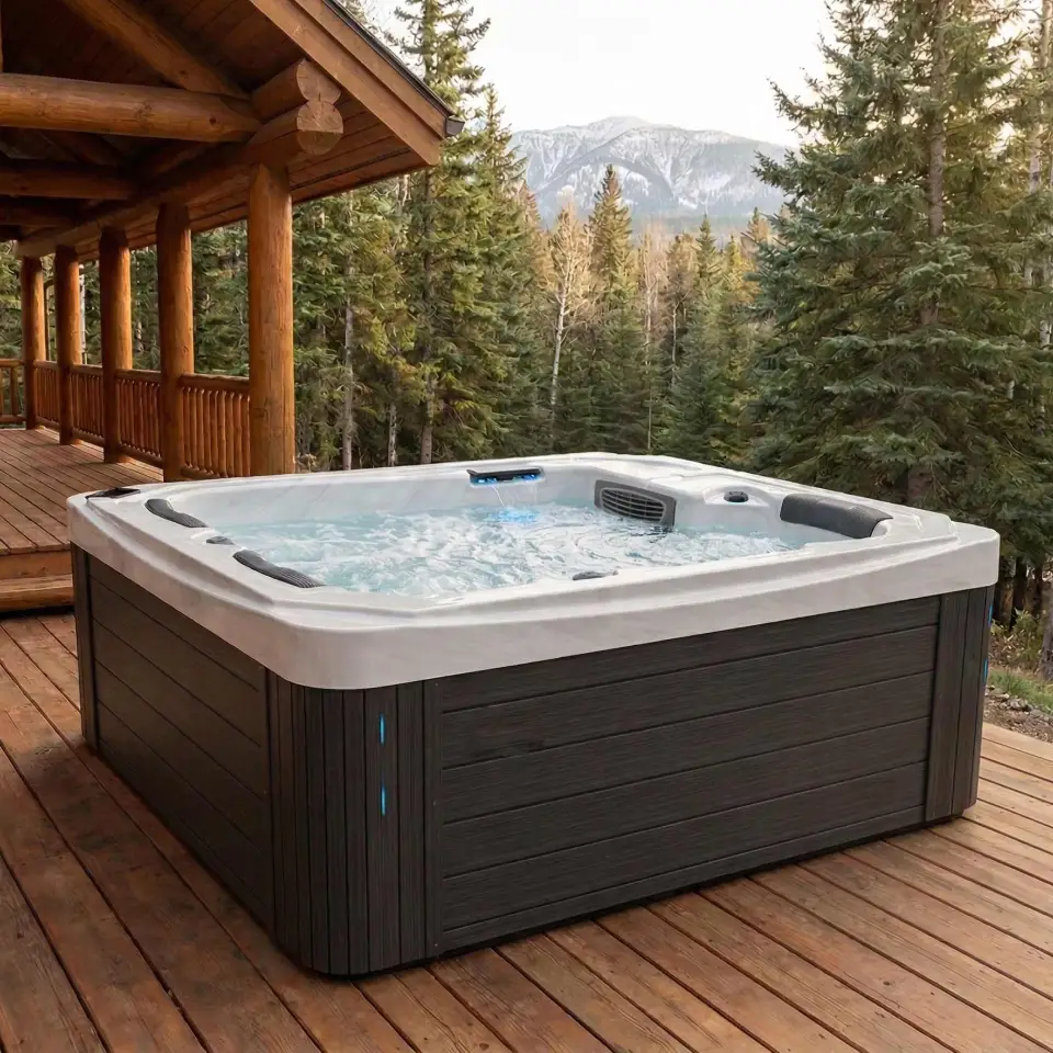 A spa with wooden style texture on the sides and white top and interior sits on a wooden deck of a cabin style residence with greenery in the background