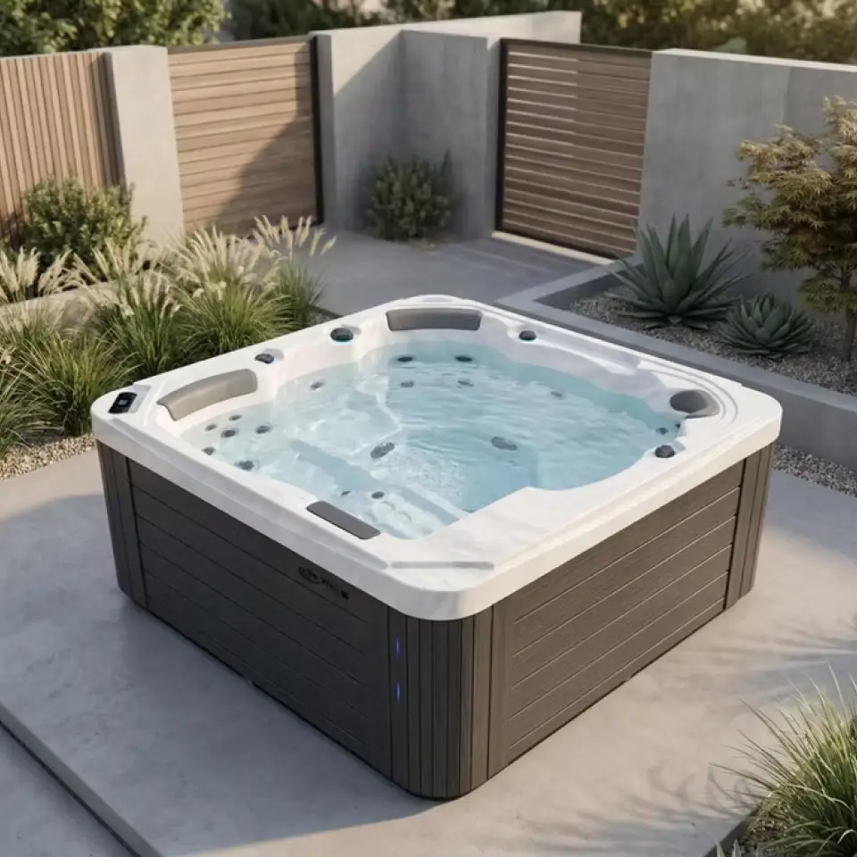A spa with wooden style texture on the sides and white marble texture for the top and interior sits on a concrete patio in a walled in outdoor area with greenery around